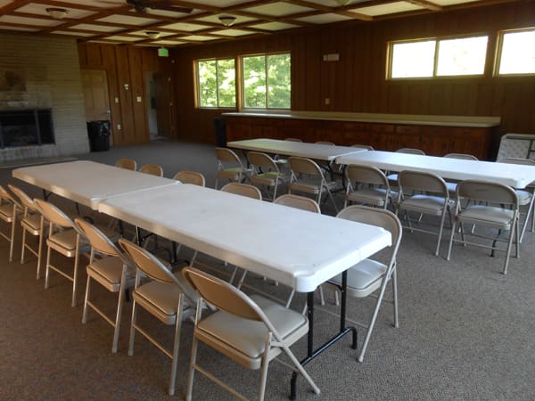 Tables and chairs set up inside of recreational building