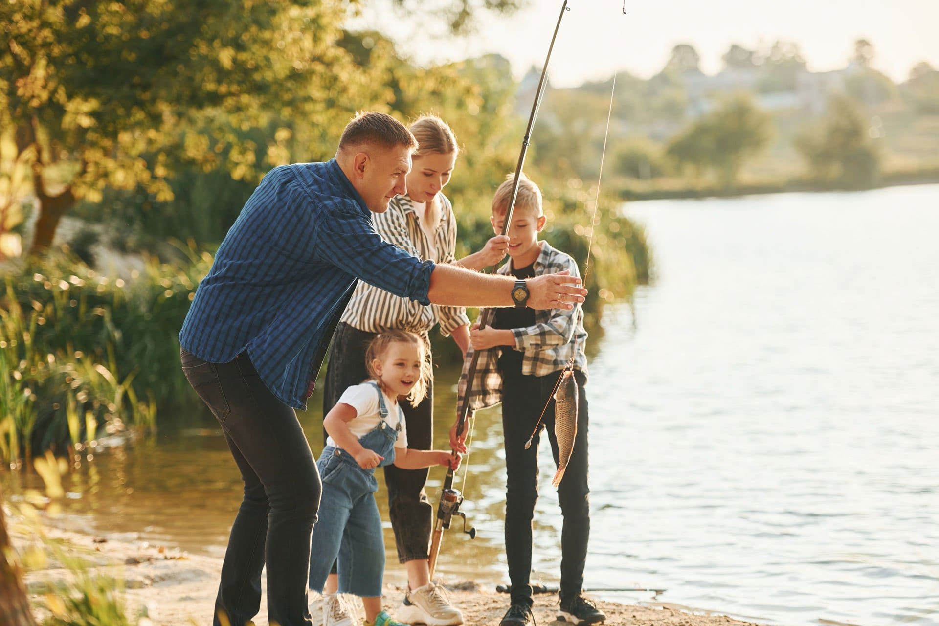 father-and-mother-with-son-and-daughter-on-fishing-2022-01-18-23-41-30-utc family fishing on the lake