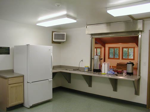 Kitchen area inside rental hall with fridge and appliances
